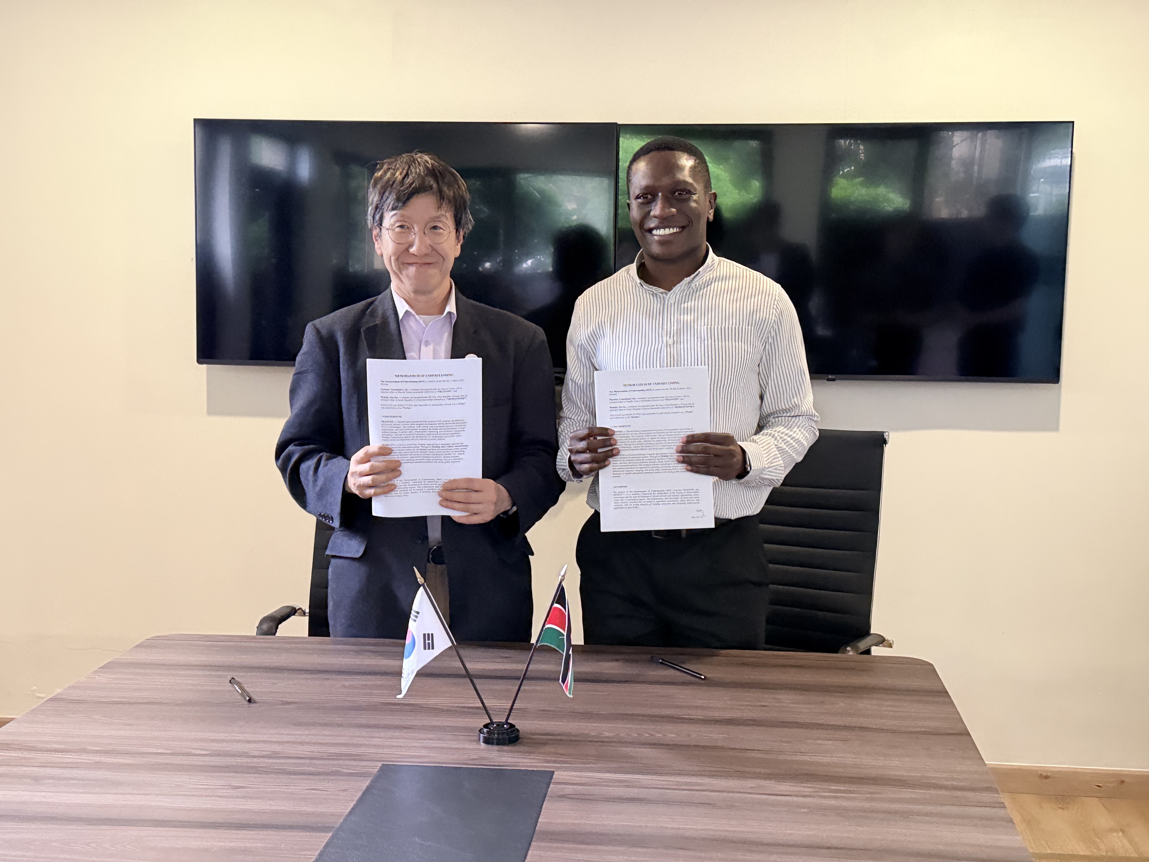 Andrew Cho (left), Vice President of Global Business at Mobility One, and Noah Odongo (right), Managing Director of Phantom Technology, Kenya, pose for a commemorative photo during the MOU signing ceremony.